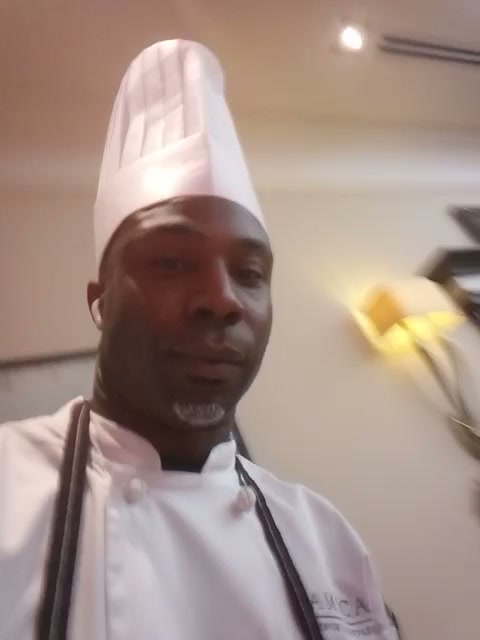 Chef Whittaker in a tall toque and white Amica chef coat